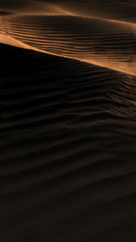 Dunes de sable sombre aux lignes ondulées, symbole de reconstruction intérieure et de retour à l’équilibre